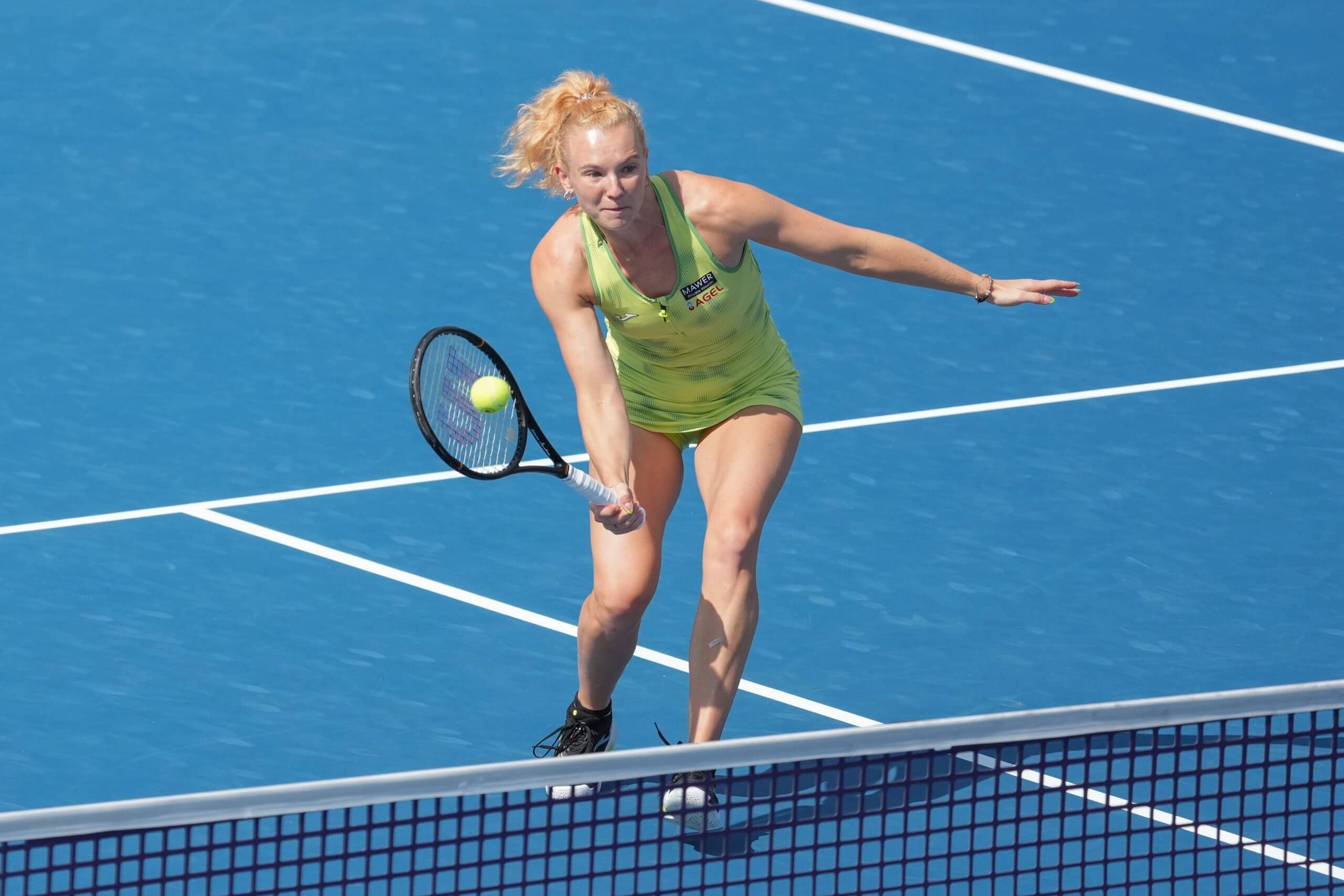 Kateřina Siniaková executes a forehand volley, eyes focused on the ball.